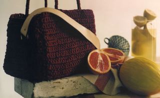 Burgundy crochet bag displayed with fruit