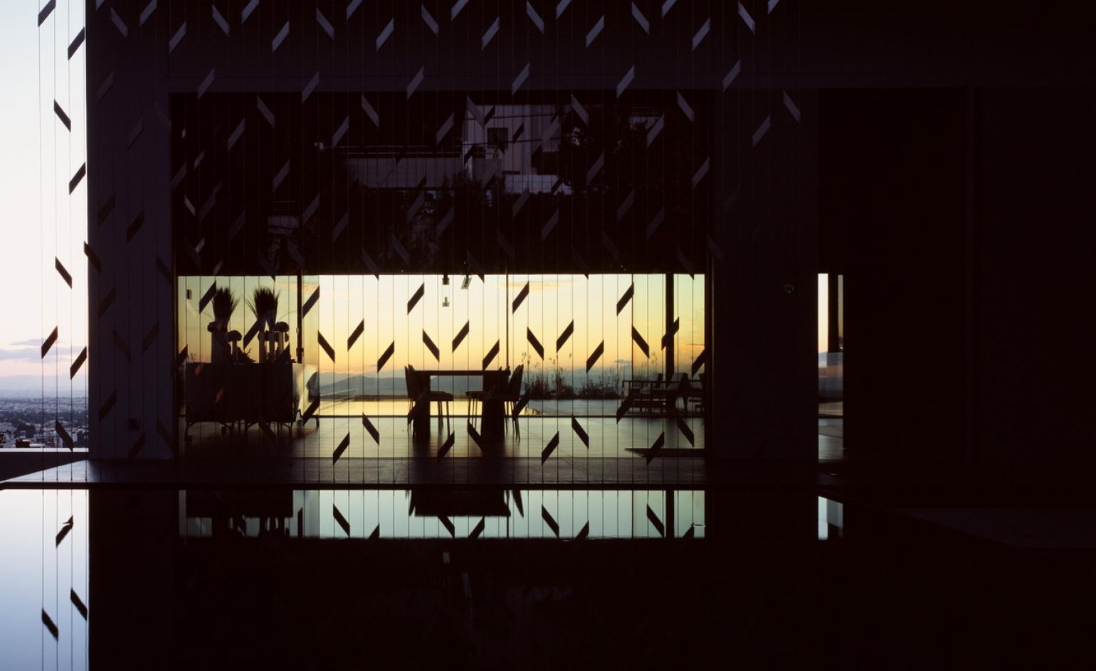Exterior looking in at dusk at reflection house in Athens