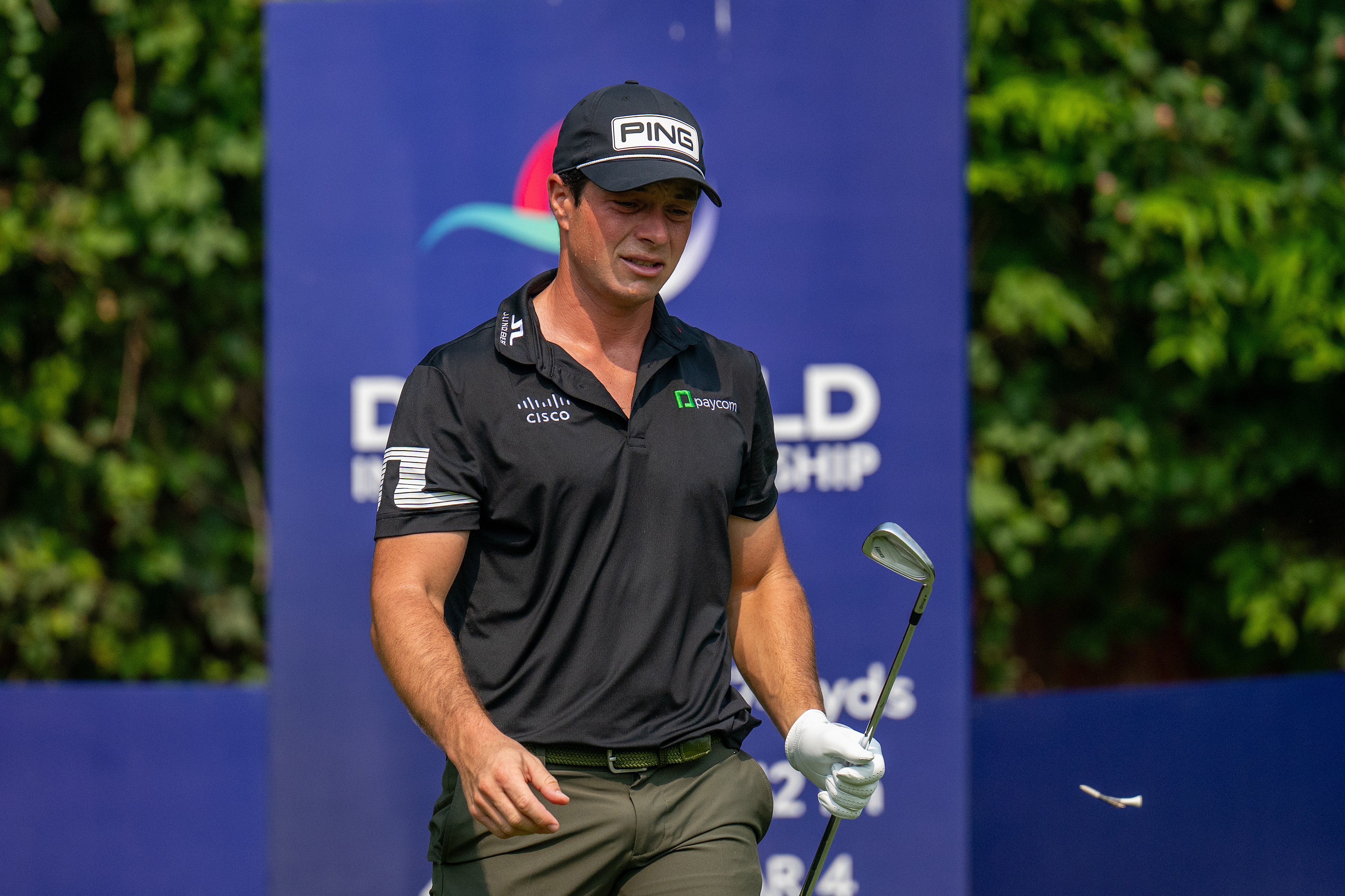 Viktor Hovland walks off the tee holding an iron