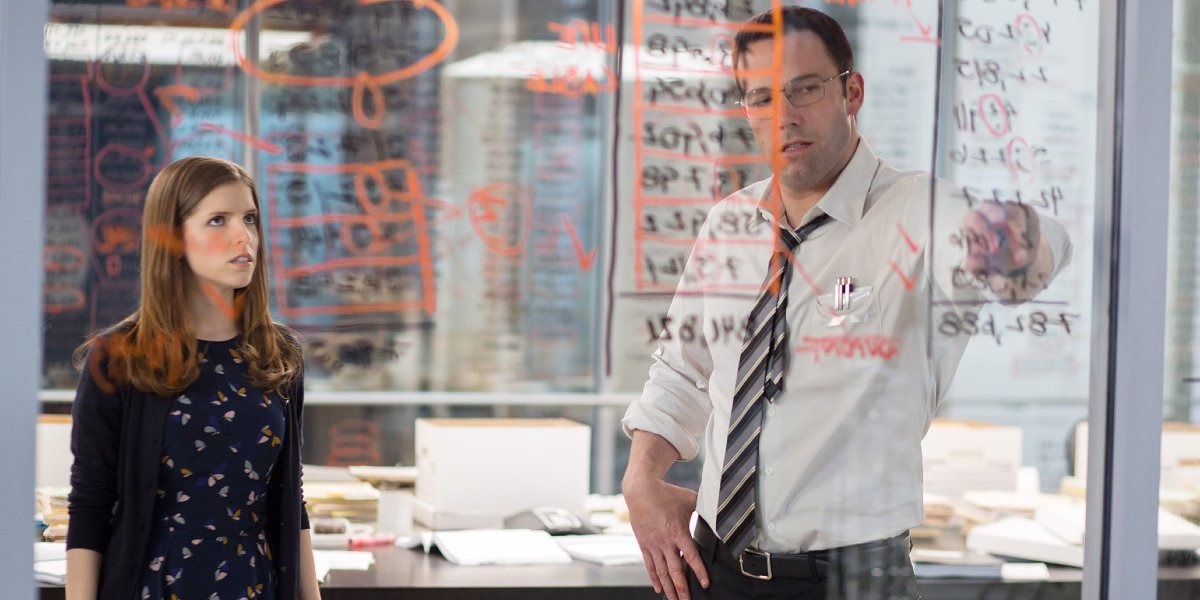 The Accountant Anna Kendrick and Ben Affleck looking over numbers on the wall