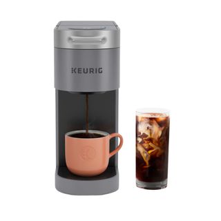 The Keurig K-Slim + Iced in grey with a pink mug and a cup of iced coffee on the side