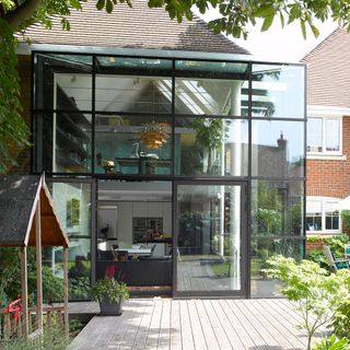 Outside view of a modern conservatory extension on a modern home showing floor to ceiling windows