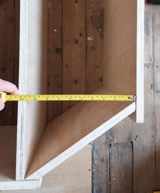 wood parts being measured with yellow tape measure