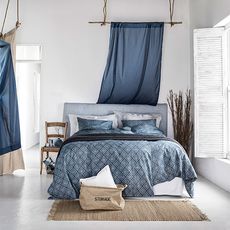 bedroom with white wall and bed with cushions