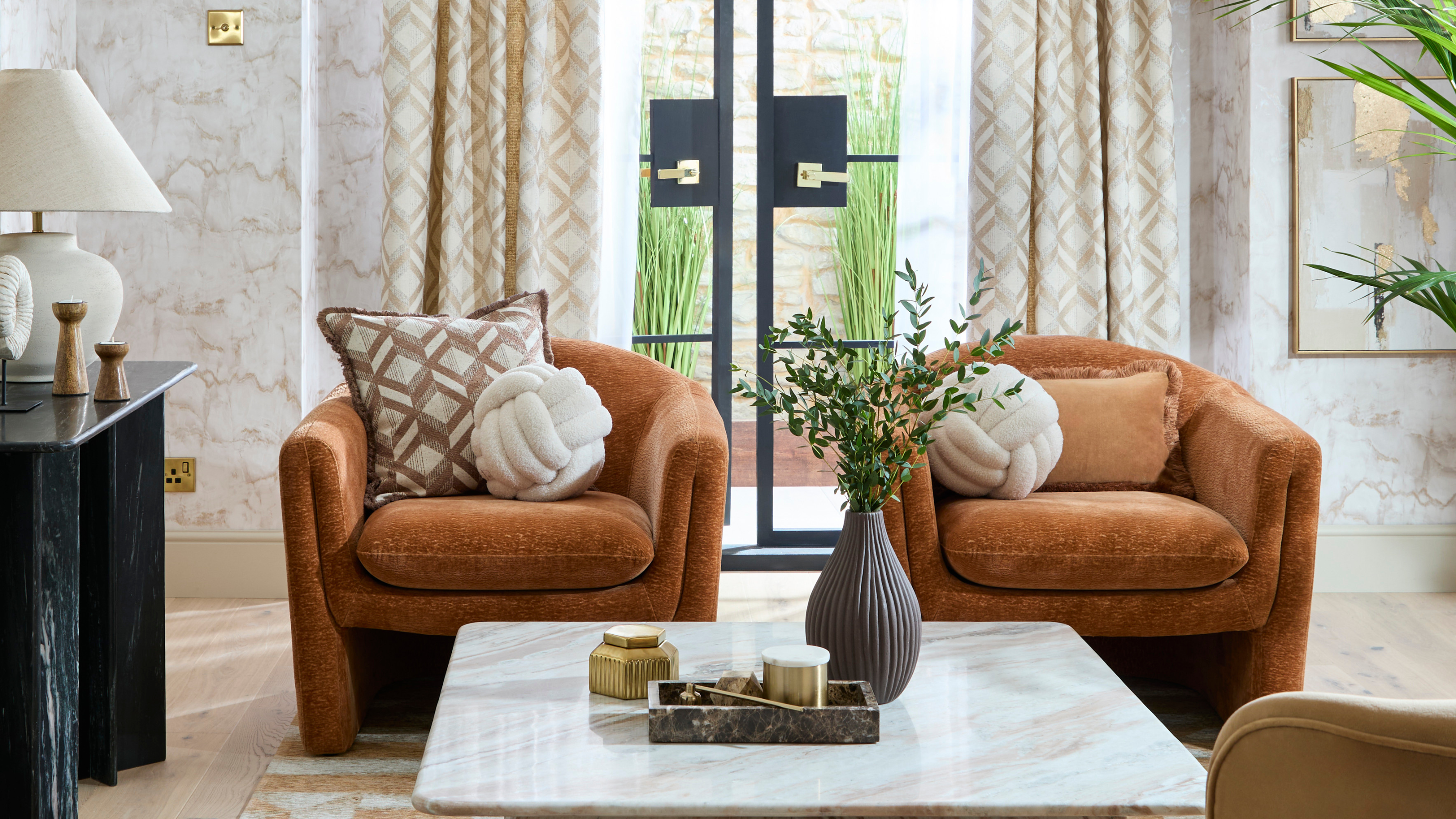 Contemporary living room with marble coffee table and brown chenille armchairs.