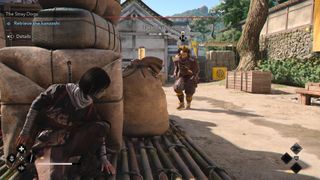 Naoe takes corner cover as a samurai daisho in Assassin's Creed Shadows approaches in Takatsuki Castle