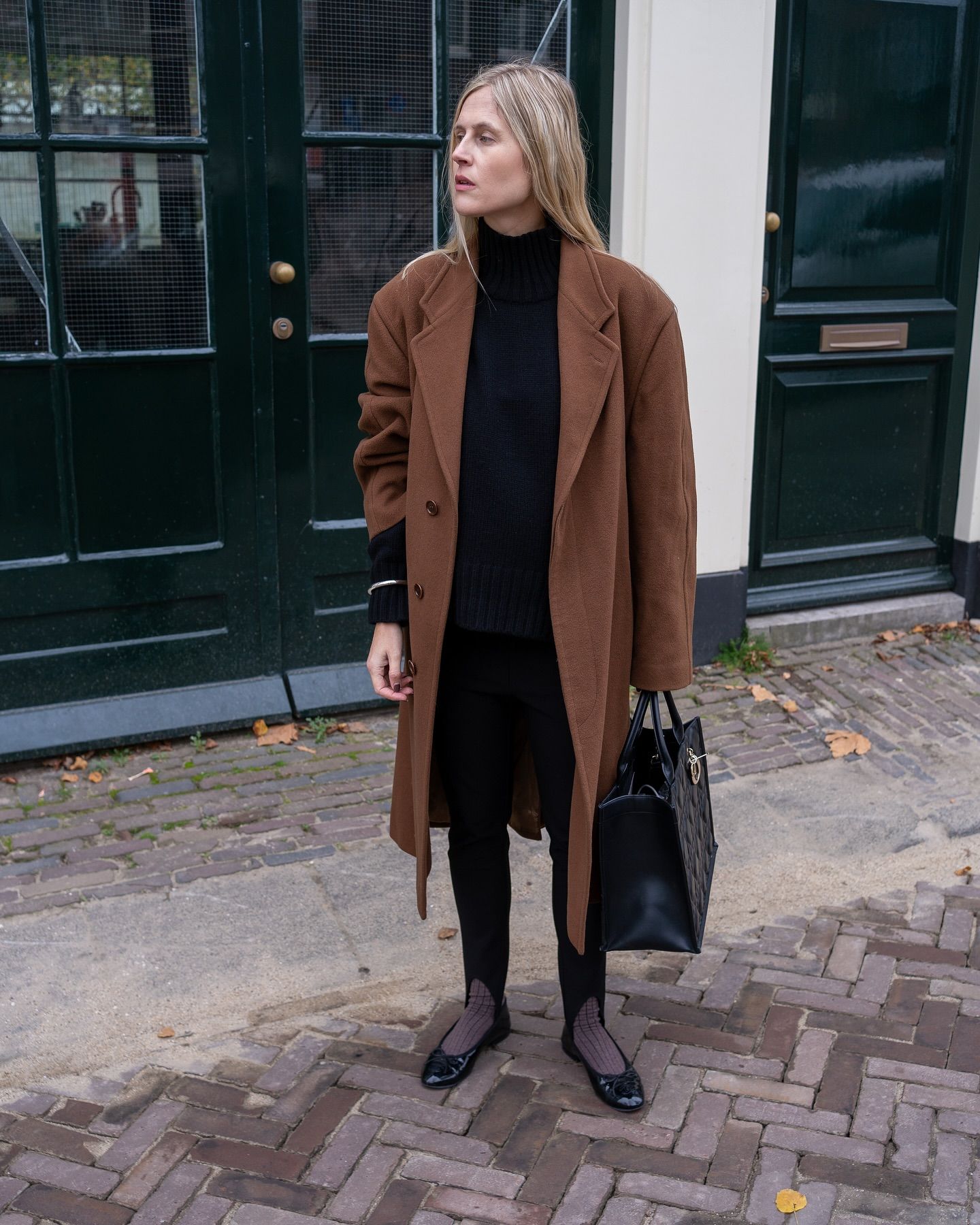 Fashion influencer @lindatol_ wears a chic outfit with basic black leggings.