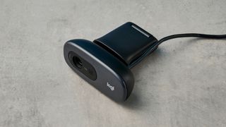 a small, black, oblong-shaped webcam with a universal attachment clip and a logi logo