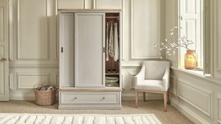 neutral bedroom with wardrobe, armchair and wall panelling