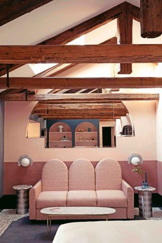 Seating area, couch with side light fixtures, 2 tone wall colour, exposed roof trusses