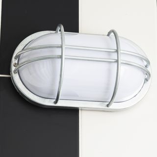 bulhead light with white grill on white and grey wall