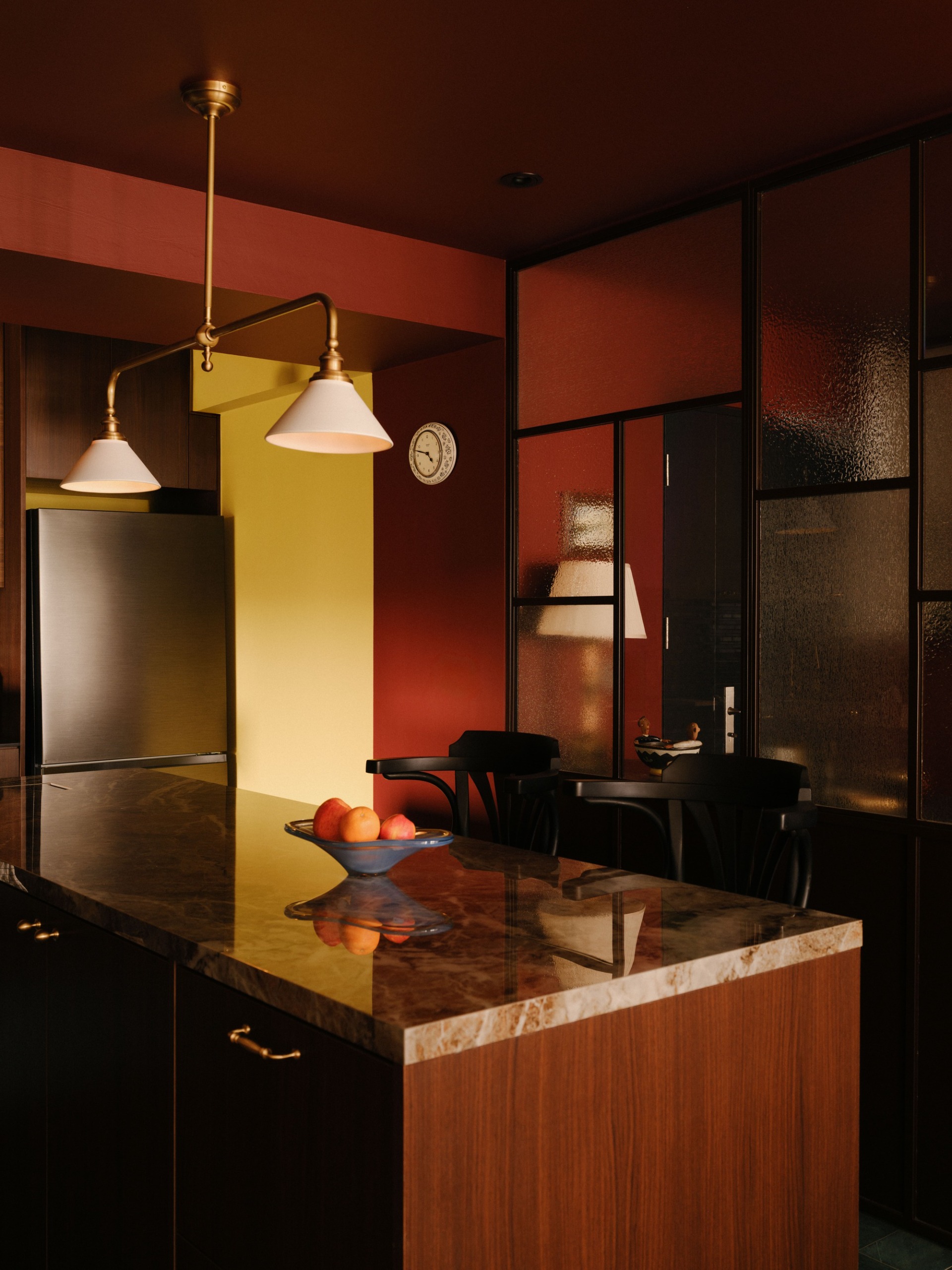a deep red kitchen with butter yellow accents, timber cabinetry and a stone benchtop
