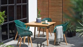 small patio with table and chairs and a single fence panel