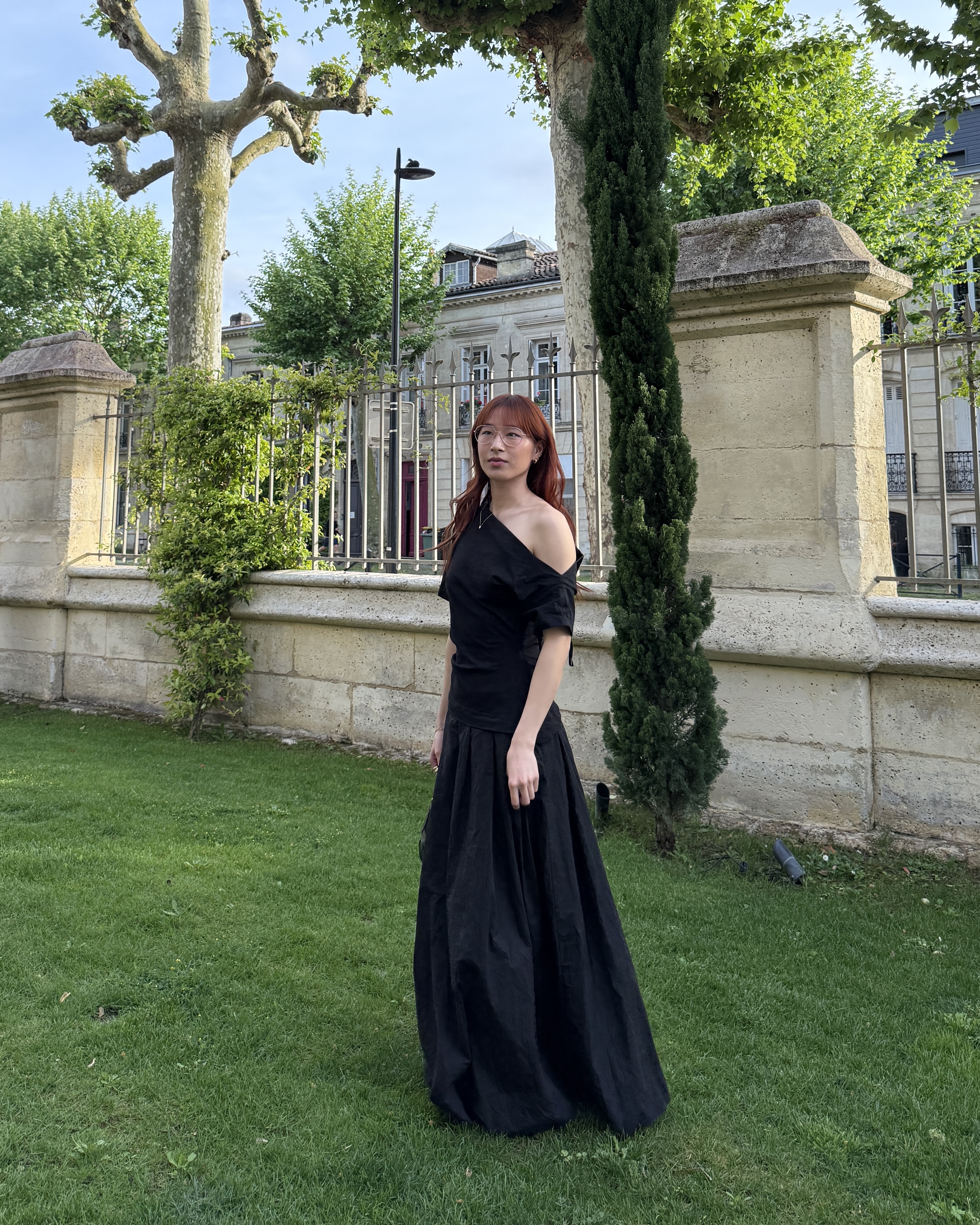 @kristinamichelleang wearing a black one-shoulder dress in Paris.