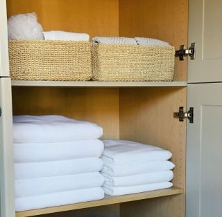 Organized linens in wooden cupboard space