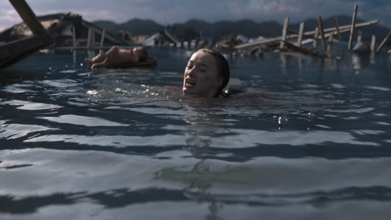 Lisa floating in water waiting for oncoming shark while baby floats in background in Netflix's Thrash
