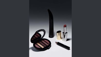 Byredo beauty makeup collection with mascara in black case, eyeshadow palette with five shades of red, red eyeliner pencil, and red lipstick