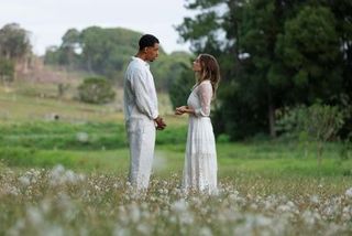 Man and a woman dressed in white on a field