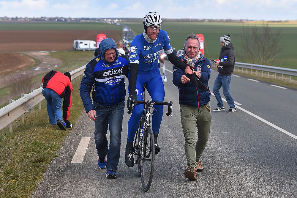 Stijn Vandenbergh (Etixx-QuickStep) is helped back on the road.