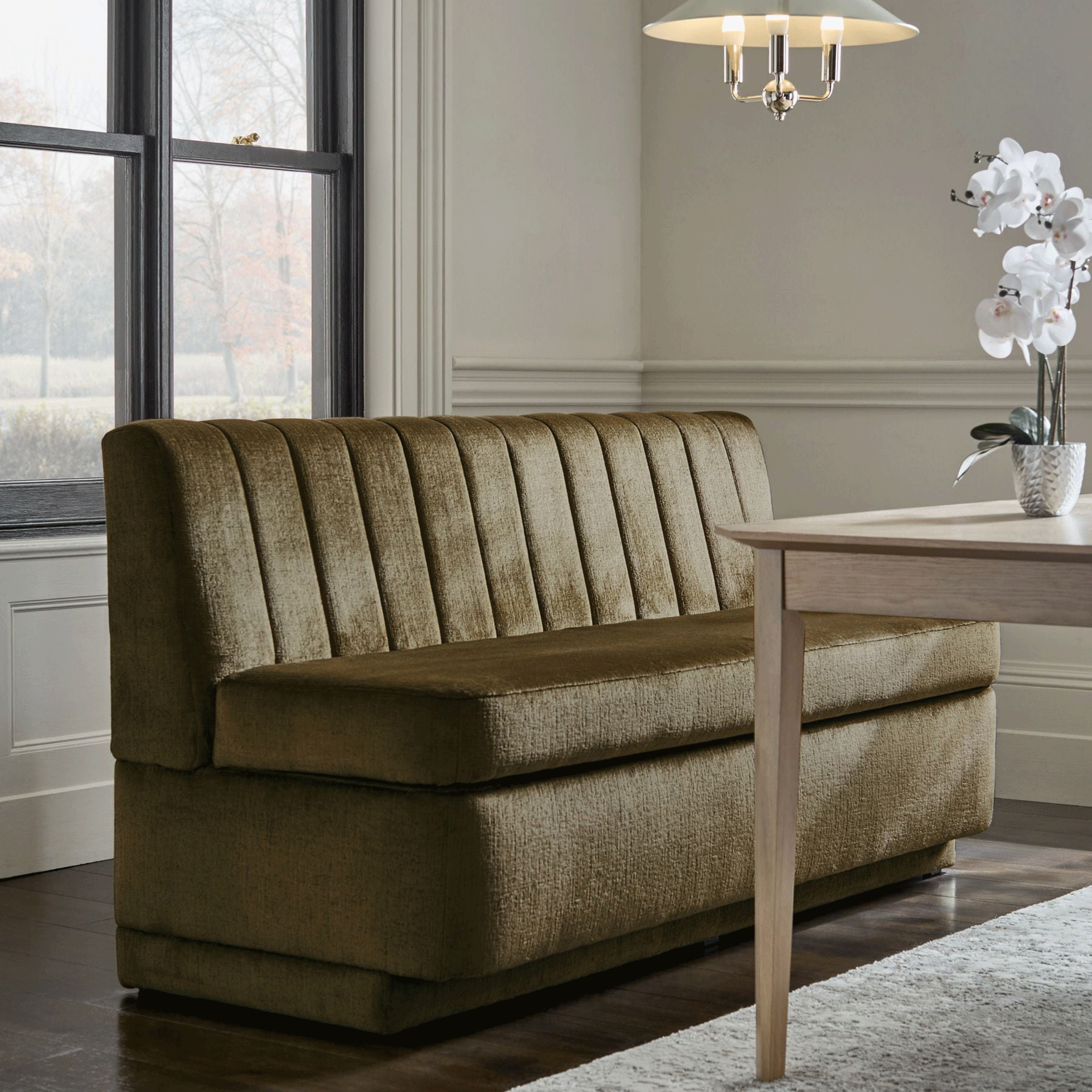Green chenille upholstered storage bench in a white room