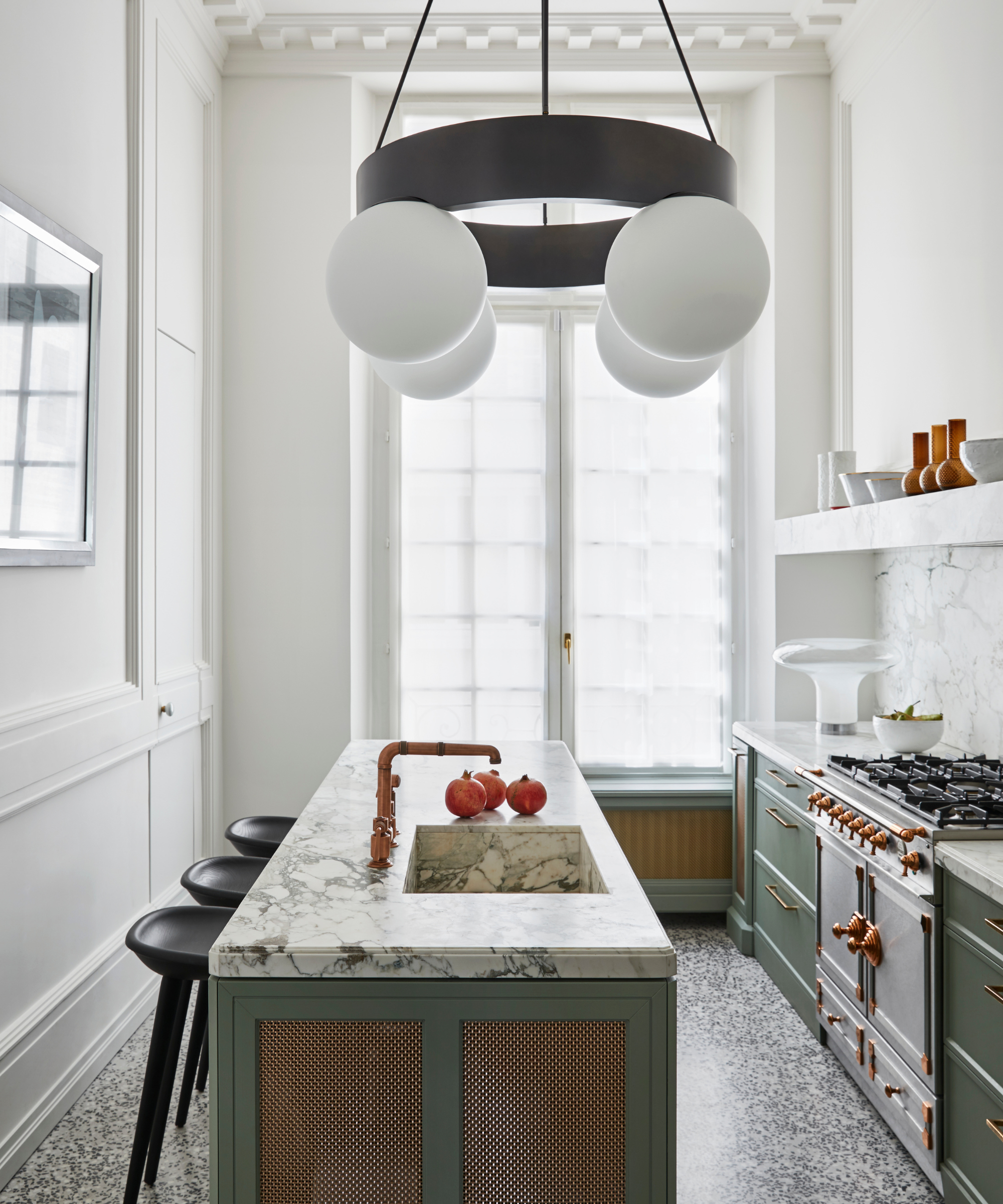 Small modern kitchen with large windows, marble island and large white and black iron sculptural pendant