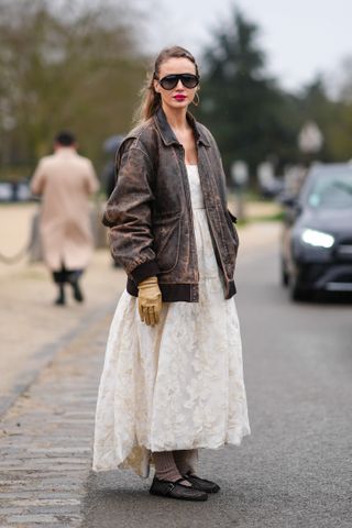 a guest at Paris Fashion Week wears a lace dress and the mesh flats trend
