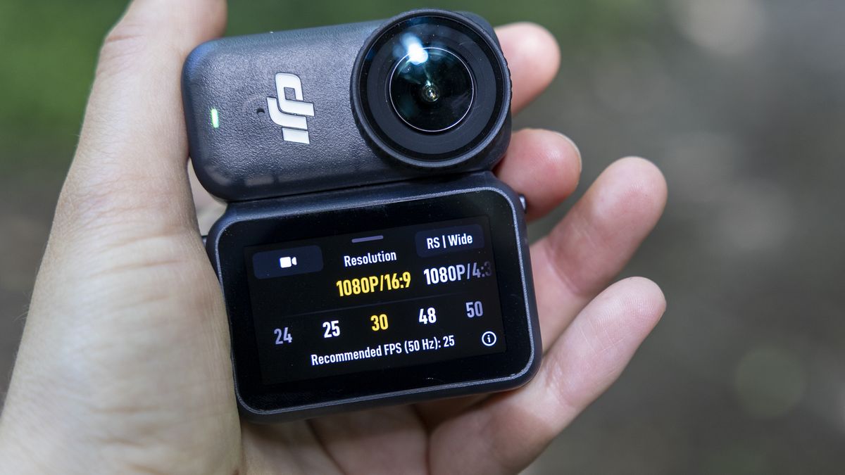 A female photographer holding the DJI Osmo Nano action camera