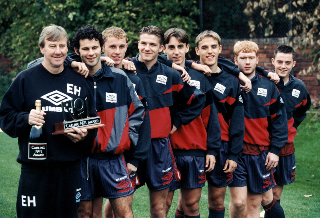 Manchester United youth team coach Eric Harrison is awarded a bottle of champagne and and special trophy by Premier League sponspors Carling for his outstanding work. He has guided his teenage prodigies to three FA Youth Cup Finals in four seasons, including twice as winners. Seven of the players who manager Alex Ferguson has been able to call upon for the first team stand beside him left to right: Ryan Giggs, Nicky Butt, David Beckham, Gary Neville, brother Phil Neville, Paul Scholes and Terry Cooke. Circa 1992. (Photo by Staff/Mirrorpix/Getty Images)