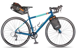 The Islabike adult Luath turned in to a gravel bike with a oversized saddle bag and front panners mounted on the bike