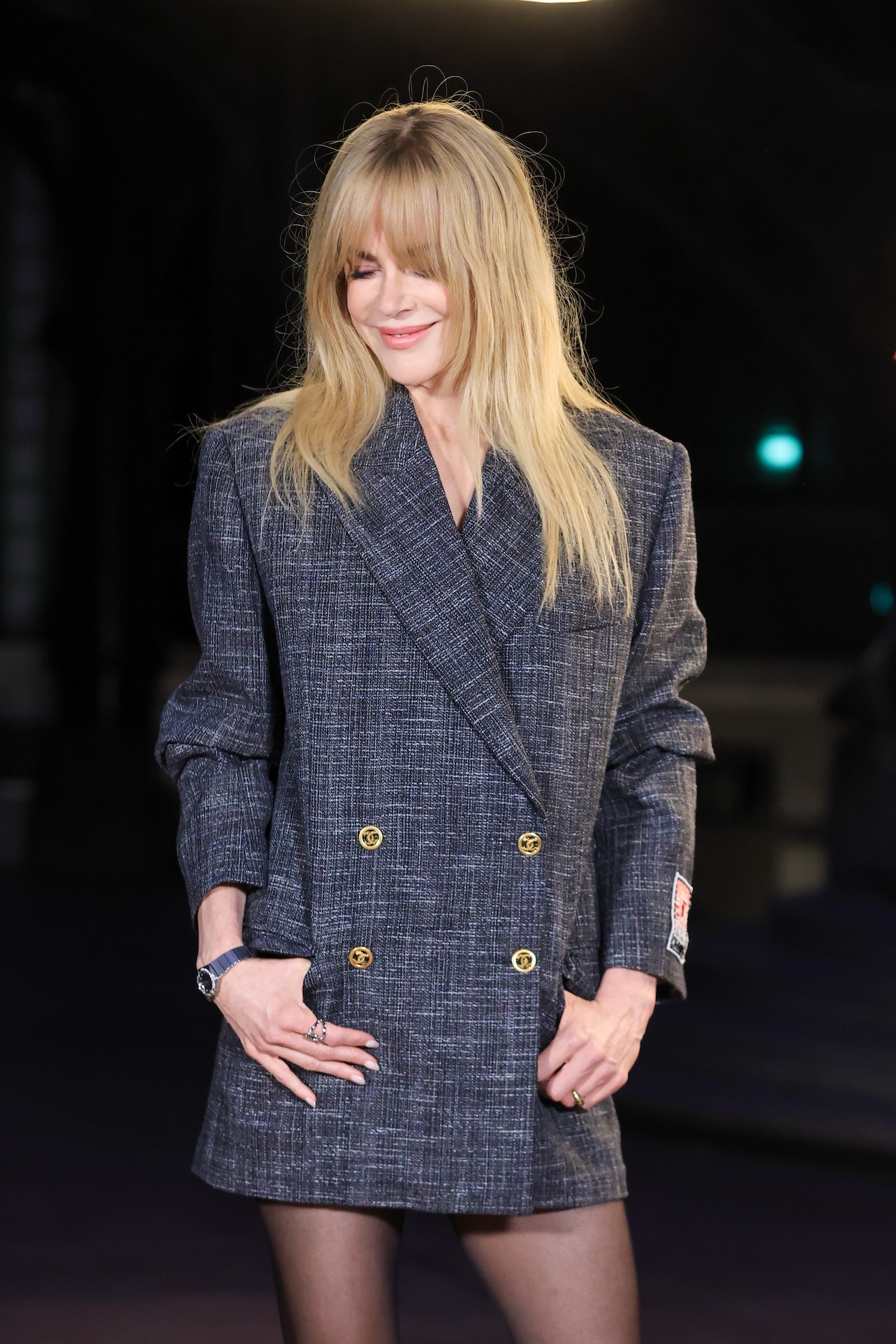 Nicole Kidman smiling in a blazer dress, with a mysterious ring on her left hand.