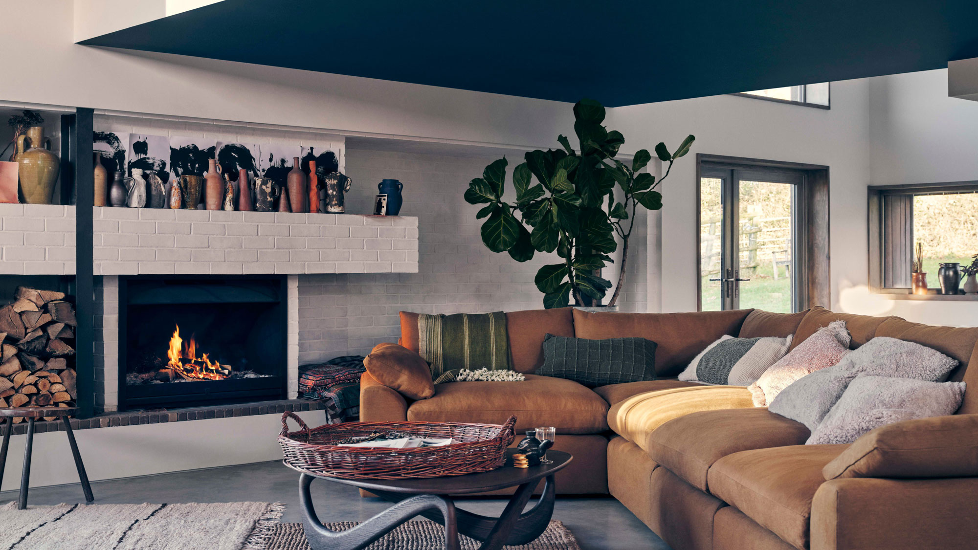 large leather sofa with modern open fire in living room with low ceiling