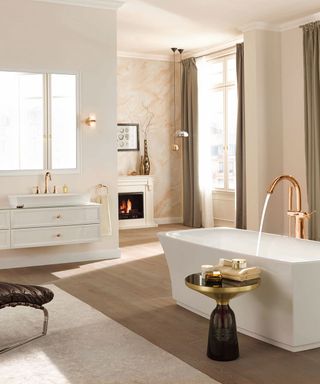 A neutral bathroom with wooden floor, white fittings and rose gold faucets.