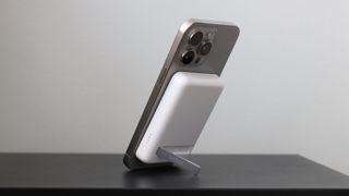 Belkin BoostCharge Magnetic Wireless Power Bank 5K + Stand with iPhone 15 Pro Max stood on its stand