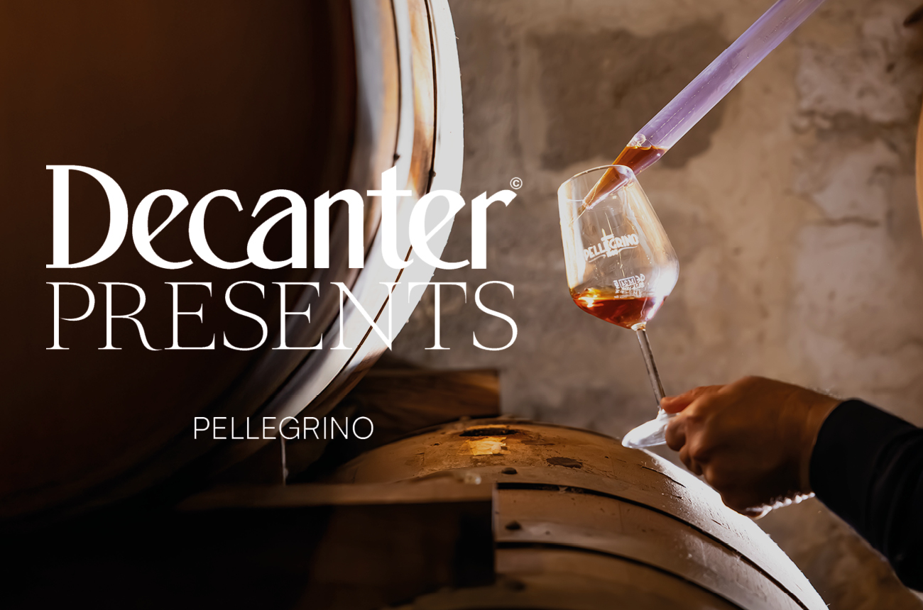 Winemaker extracting a wine sample from a barrel using a wine thief