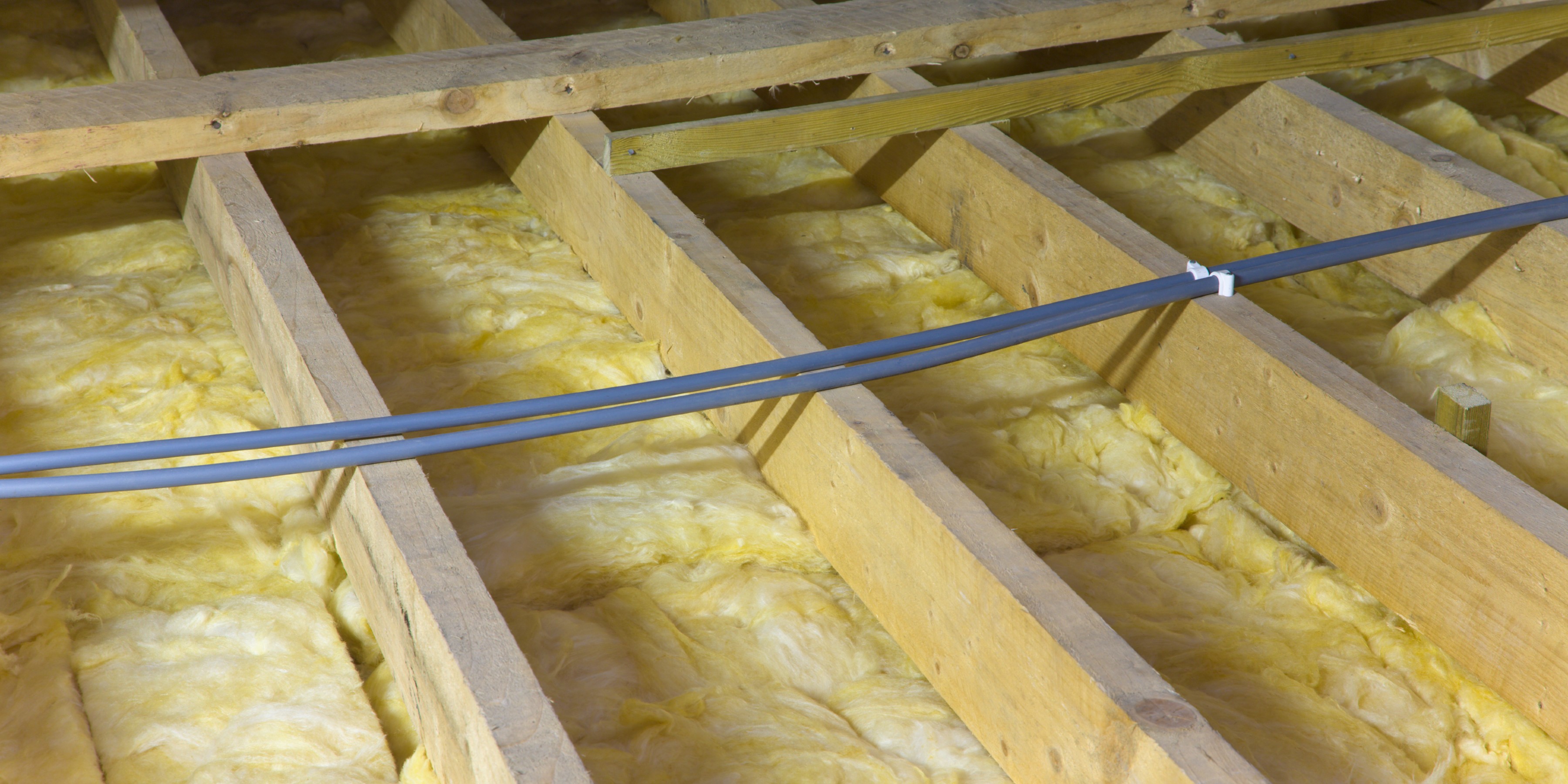 Cables running over mineral wool insulation installed between joists in the loft 