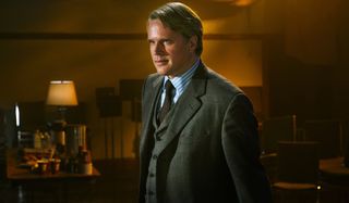 Cary Elwes stands in a dimly lit room in Saw: The Final Chapter.