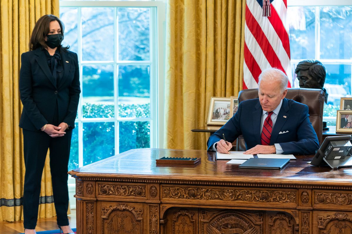 President Joe Biden, joined by Vice President Kamala Harris, signs two executive orders on healthcare Thursday, Jan. 28, 2021, in the Oval Office of the White House.