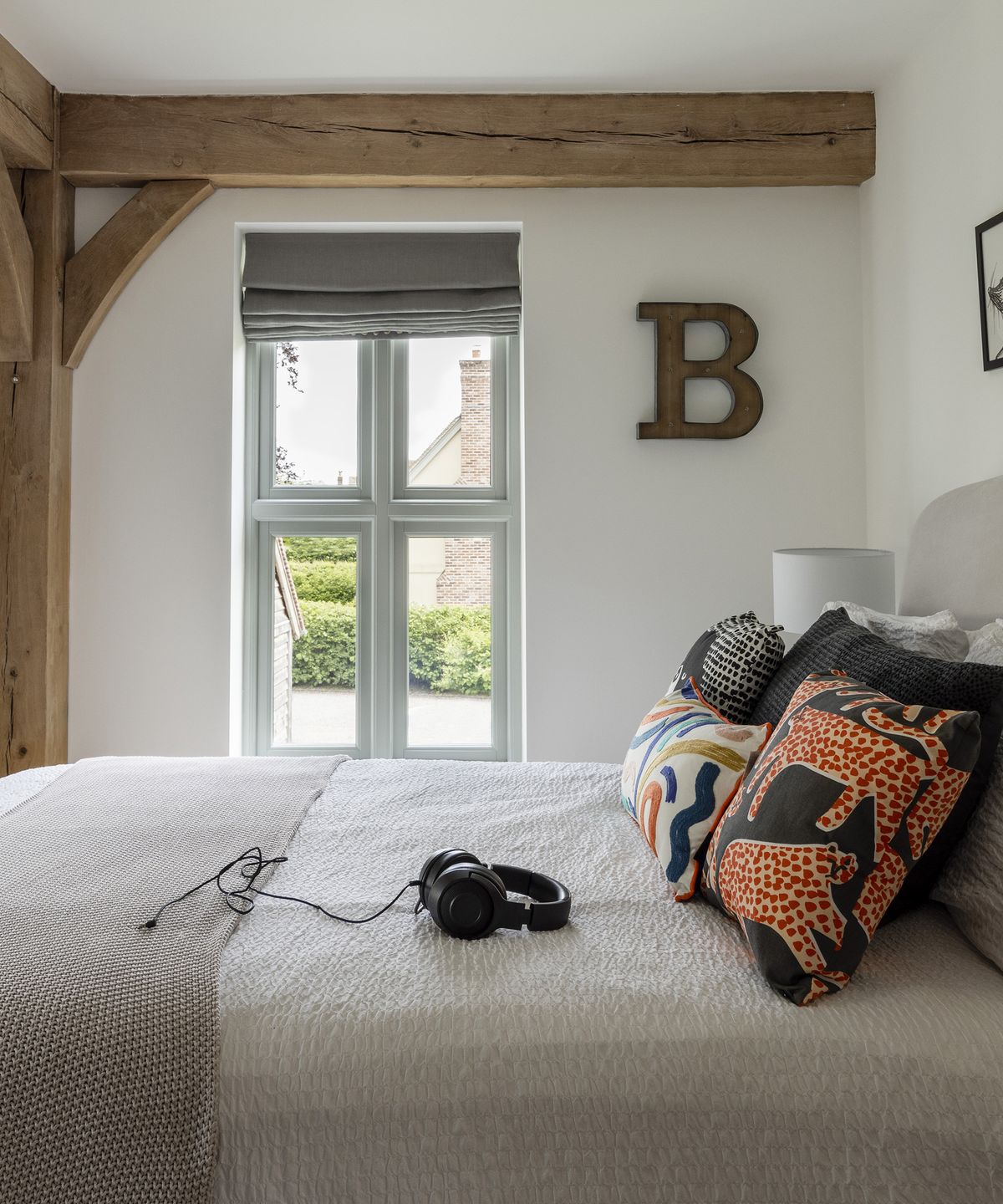 Small double bedroom with exposed oak beams and neutral walls