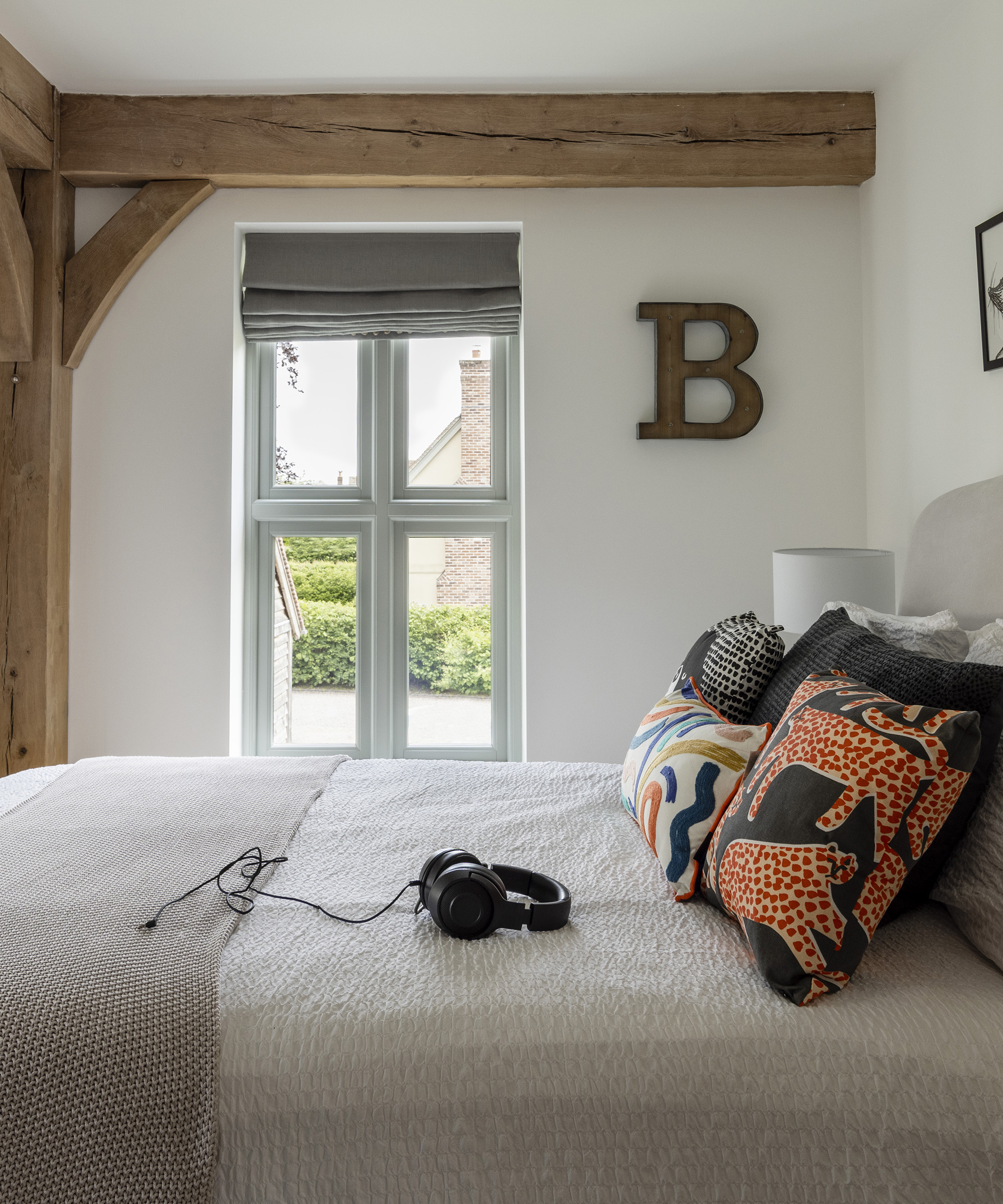 Small double bedroom with exposed oak beams and neutral walls