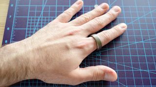Amazfit Helio ring on a person's finger on a table