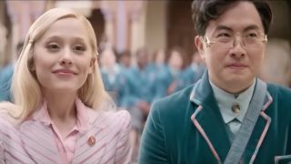 Ariana Grande and Bowen Yang in Wicked sitting next to each other.