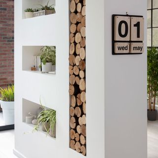 white wall with wooden logs and calender