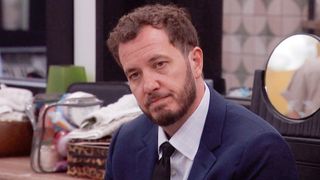 Rick in a suit looking very somber. 