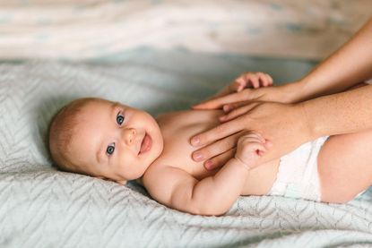 Baby masage. Four month old baby smiling doing gymnastics