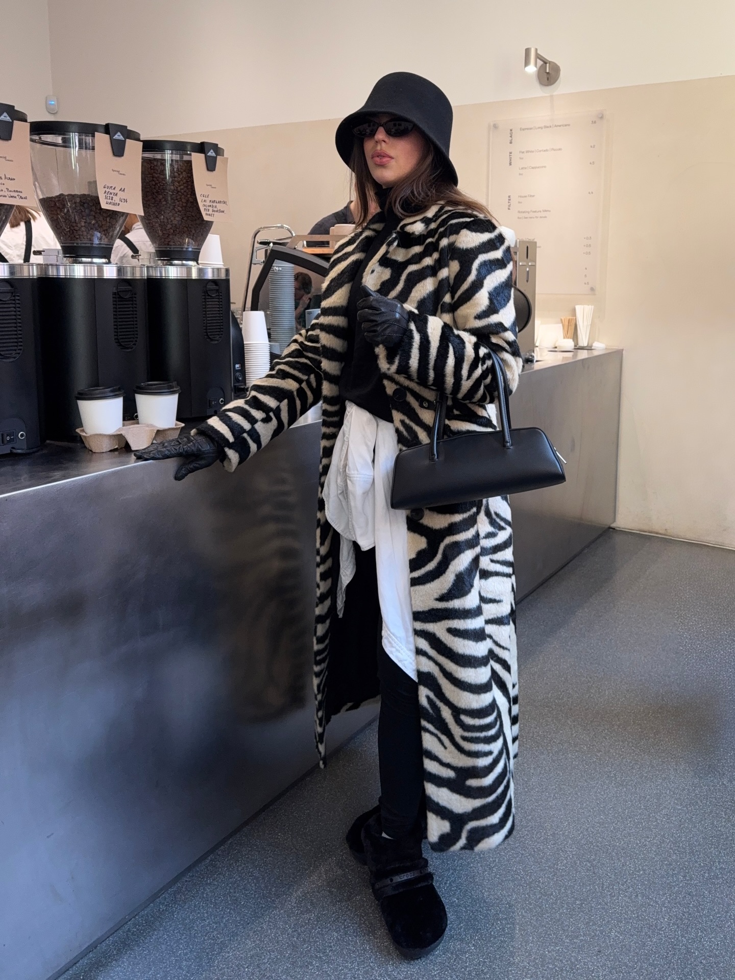 Hetty wears a zebra print coat, leggings and black boots