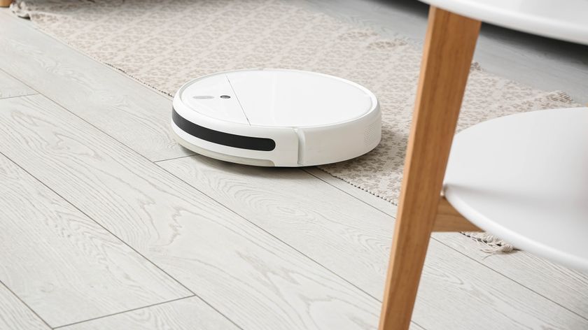 White robot vacuum on white wooden floor