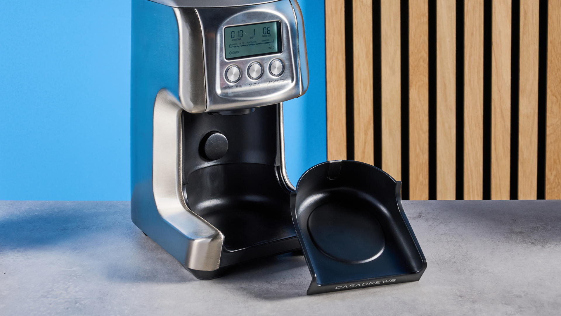 the casabrews tornado coffee grinder in silver showing the LED screen, grind adjustment dial, and photographed against a blue background