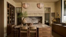 A warm neutral kitchen with bold stone countertops and a wooden island