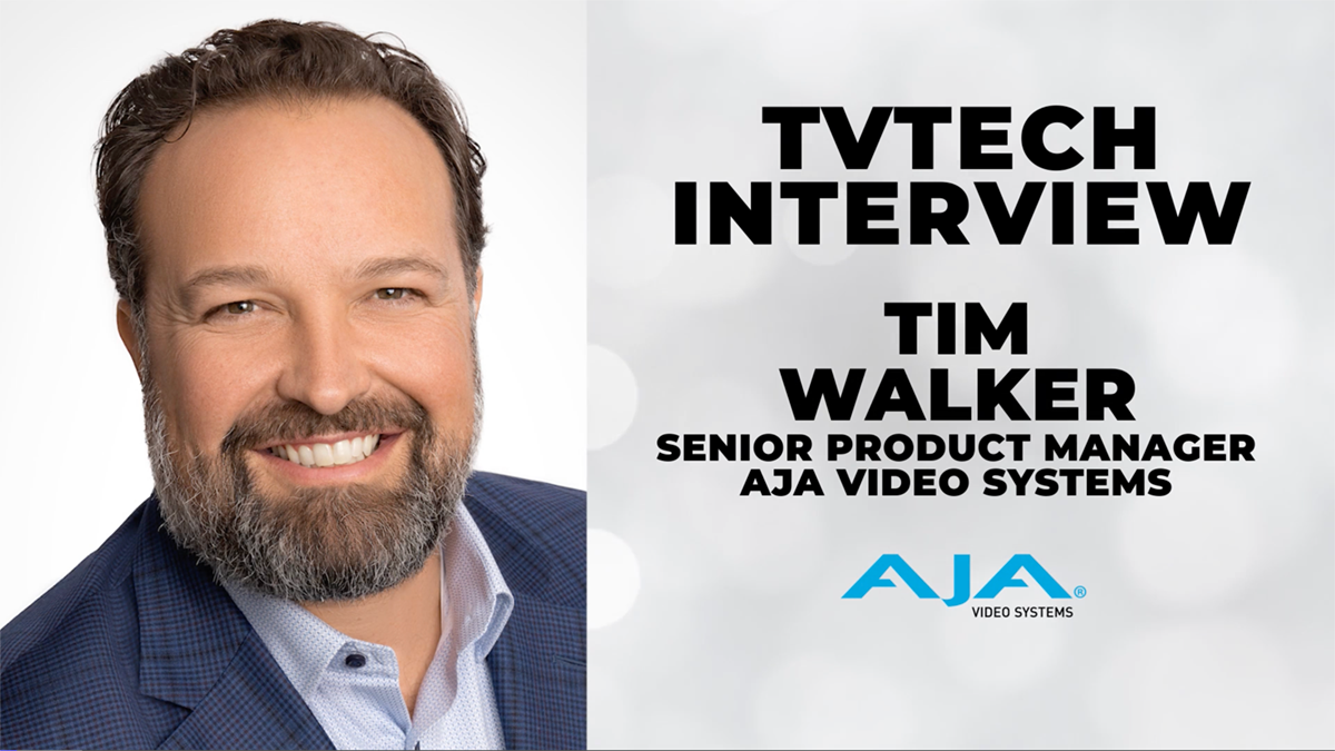 Picture of Tim Walker, a smiling male with beard, a light blue shirt and dark blue suit, no tie. 