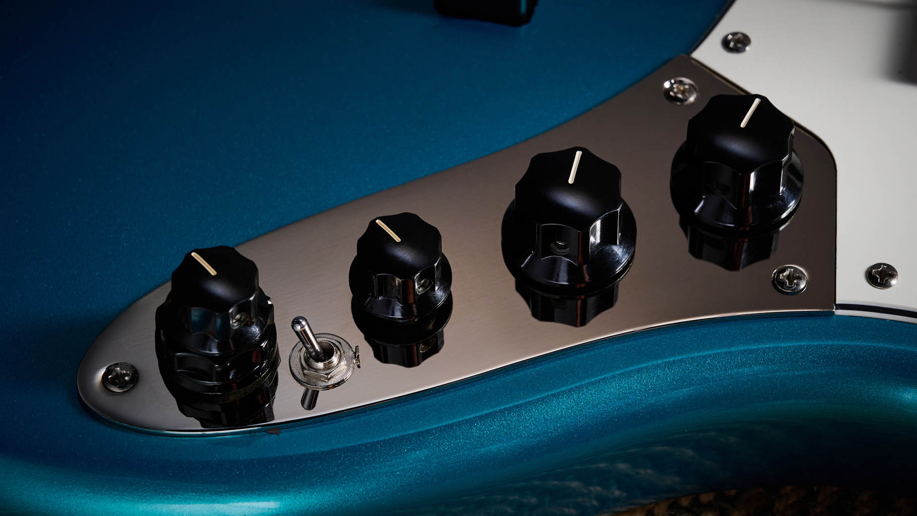 Squier Classic Vibe 70s Jazz Bass Active: finished in Ocean Turquoise, this keenly priced four-string is photographed in close-up with a patterned rug and wooden floor in the background.